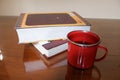 Two books with a cup of coffee on a glassed table