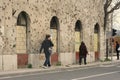 Two Bosnian passers-by in Mostar walk close to a building damaged by the war and riddled with bullets