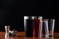 Two Boston shakers, black and red, and two jiggers for making cocktails at the bar. Shaker disassembled: glass cover
