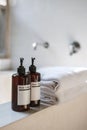 Two bottle of natural cosmetic body care on top of white ceramic bathtub