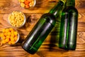 Two bottles of beer and different snacks on wooden table. Top view Royalty Free Stock Photo