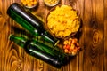 Two bottles of beer and different snacks on wooden table. Top view Royalty Free Stock Photo