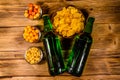 Two bottles of beer and different snacks on wooden table. Top view Royalty Free Stock Photo