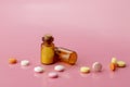 Two bottles of brown glass and colorful round tablets and pills scattered around them Royalty Free Stock Photo