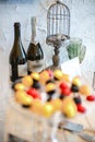 Two bottles of champagne, Easter eggs in a decorative cage and glasses in the background, candies in colored glaze on a glass Royalty Free Stock Photo