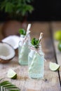 Two bottles of coconut water with mint and lime on a wooden table. Vegetarian drink. Mojito. Copy space Royalty Free Stock Photo