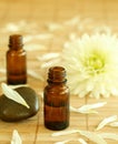 Two bottles of essence oil and chrysanthemum. Royalty Free Stock Photo