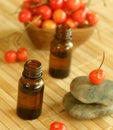 Two bottles of essence oil, stones and fresh cher Royalty Free Stock Photo