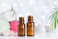 Two bottles with essential oil, towel and candles on white table with bokeh effect. Spa, aromatherapy, wellness, beauty theme. Royalty Free Stock Photo
