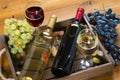 Two bottles, glasses of wine, bunches of grapes in wooden box Royalty Free Stock Photo