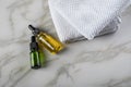 Two bottles of green natural serum and yellow organic beauty face oil for cosmetic anti age treatment skin care on towels and