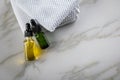 Two bottles of green natural serum and yellow organic beauty face oil for cosmetic anti age treatment skin care on towels and