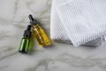 Two bottles of green natural serum and yellow organic beauty face oil for cosmetic anti age treatment skin care on towels and