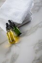 Two bottles of green natural serum and yellow organic beauty face oil for cosmetic anti age treatment skin care on towels and