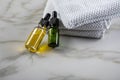 Two bottles of green natural serum and yellow organic beauty face oil for cosmetic anti age treatment skin care on towels and