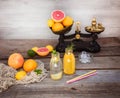 Two bottles with homemade lemonade and orange fresh juice with mint and ice on the rustic wooden background with fresh citrus in Royalty Free Stock Photo