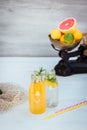 Two bottles with homemade lemonade and orange fresh juice with mint and ice on the white wooden background with fresh citrus in Royalty Free Stock Photo