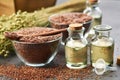 Two bottles of linseed oil and glass bowls of whole flax seeds. Bundle of linen flax plants