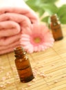 Two bottles of massage oil, towel and gerber. Royalty Free Stock Photo