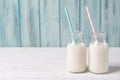 Two bottles of milk with straws, wooden background Royalty Free Stock Photo