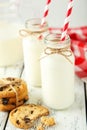Two bottles of milk with striped straws and cookies on the white wooden background Royalty Free Stock Photo