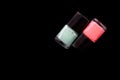 Two bottles of pink and mint color nail polish isolated on black. Beauty concept. Top view, copy space Royalty Free Stock Photo