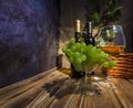 Two bottles of red and white wine on a wooden table with a bunch of grapes and a glass on a thin stem Royalty Free Stock Photo