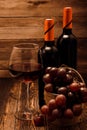 Two bottles of red wine, a glass of wine and a basket of grapes Royalty Free Stock Photo