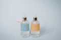 Two bottles of serum of perfume are on a blue background Royalty Free Stock Photo