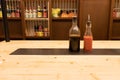 Two bottles of soy sauce and hot chili on a wooden table in an asian restaurant or chinese bar with dumplings