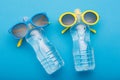 Two bottles of water on a blue background are similar to people sunbathing on the beach, bottled glasses, concept summer Royalty Free Stock Photo