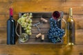 Two bottles .. of wine and grapes on wooden background Royalty Free Stock Photo