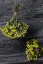 Two bouquets of statice. One is yellow, the other is multi-colored. Against the background of pine boards