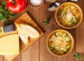 Two bowl of minestrone soup with cheese on cutting board and vegetables on rustic wooden background, top view. Royalty Free Stock Photo