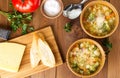 Two bowl of minestrone soup with cheese on cutting board, vegetables on rustic wooden background, top view, long width. Royalty Free Stock Photo