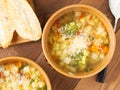 Two bowl of minestrone soup with toast on rustic wooden background, top view, close up Royalty Free Stock Photo