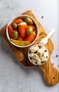 Two bowls of delicious Italian starters on an olive wood chopping board, red peppers stuffed with cheese cream, herbs, black Royalty Free Stock Photo