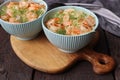Two bowls of delicious shrimp alfredo with garlic and cream sauce over pasta on rustic wooden table Royalty Free Stock Photo