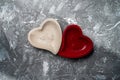 Two bowls in the form of hearts lie on a light concrete background. Union of hearts in love. Valentine`s Day Royalty Free Stock Photo