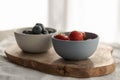 Two bowls with fresh blueberries and strawberries on woo dboard Royalty Free Stock Photo