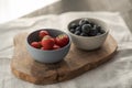 Two bowls with fresh blueberries and strawberries on woo dboard Royalty Free Stock Photo