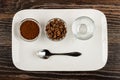 Two bowls with ground coffee and roasted coffee beans, coffee cup, spoon in plate on wooden table. Top view Royalty Free Stock Photo