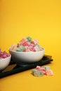 Two bowls of rahat lakoum on a tray isolated on yellow background vertical image. Turkish sweet concept Royalty Free Stock Photo