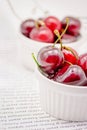 Bowls with red ripe sweet cherries with water drops on white background Royalty Free Stock Photo