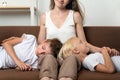 Two boy brothers put their heads on mom`s lap. Portrait of mom and calm children