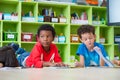 Two boy kid lay down on floor and reading tale book in preschoo Royalty Free Stock Photo