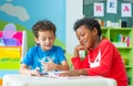 Two boy kid sit on table and reading tale book in preschool lib