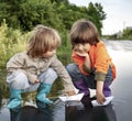 Two boy play in paper ship in puddle summer day Royalty Free Stock Photo