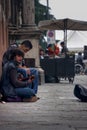 Two boy street performer playing and singing sitting on the ground