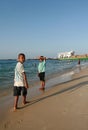 Two boys African, walking along the shoreline sandy beach, Zanzibar.